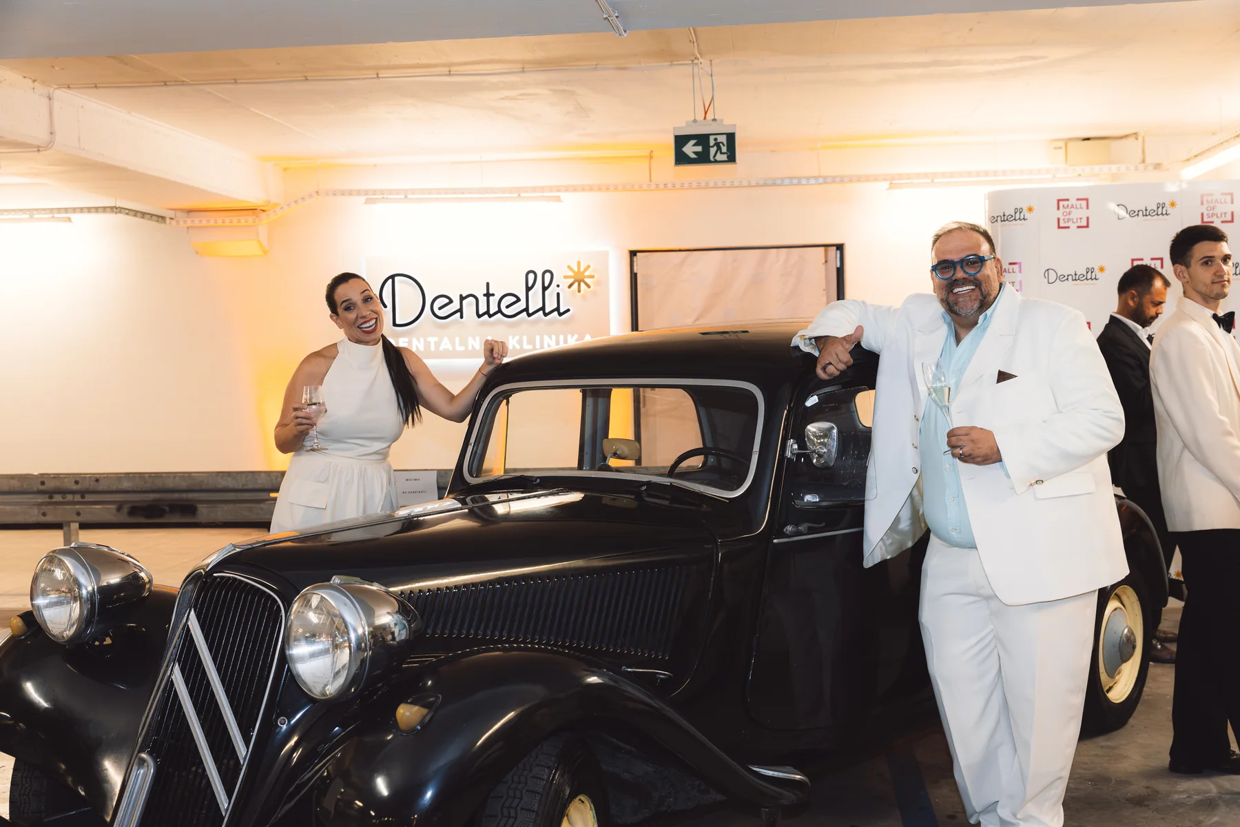 Dentelli owners posing beside a vintage car at the Casablanca-themed event